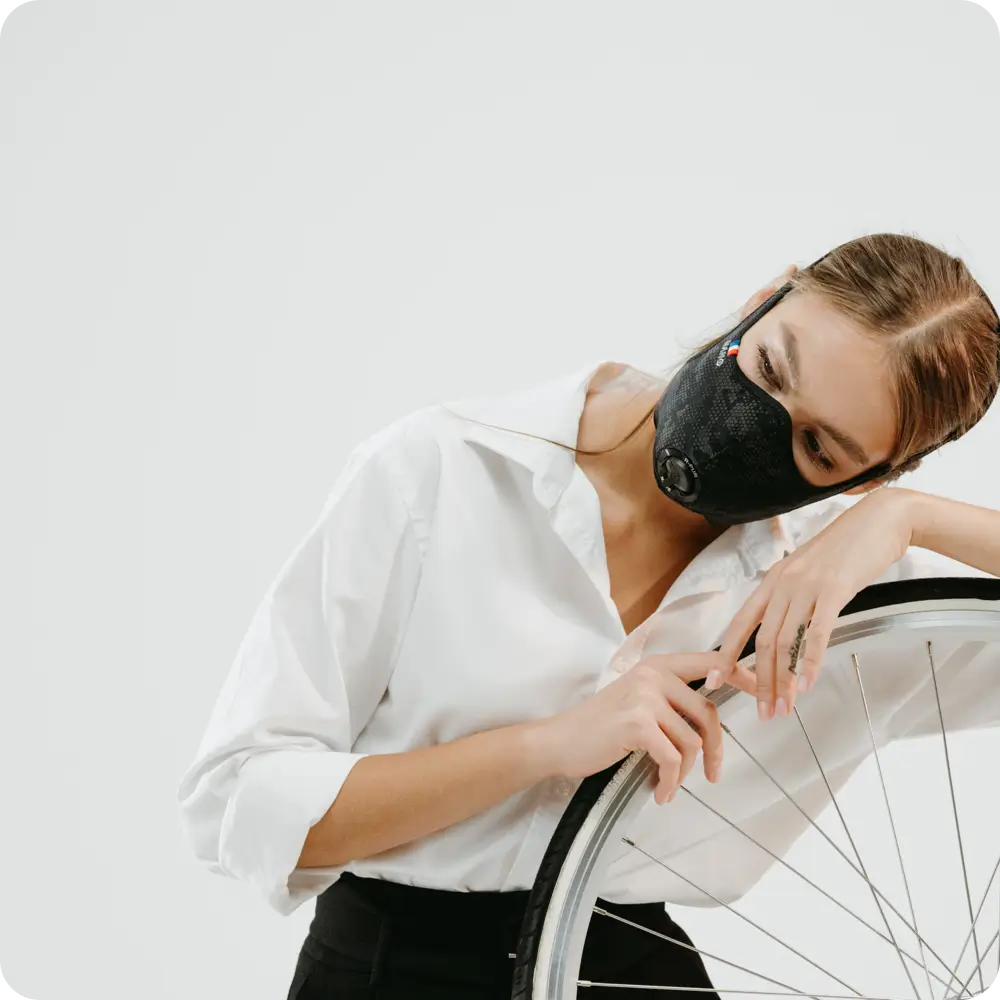 Femme avec un masque R-PUR sur une roue de vélo