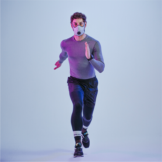 Runner wearing a white R-PUR running mask looking straight ahead and running toward the camera