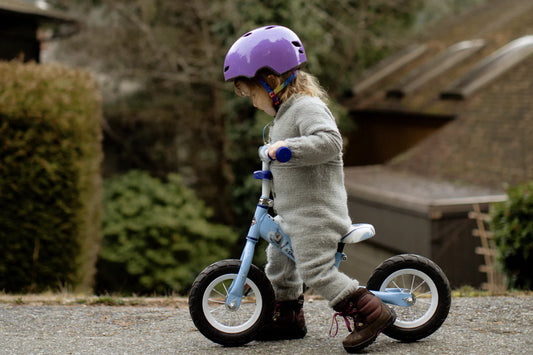 enfant qui fait du vélo avec un casque bleu