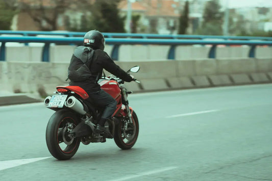 Personne en moto sur la route, avec casque intégral