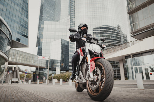 Homme en ville à moto, avec un casque et un masque moto