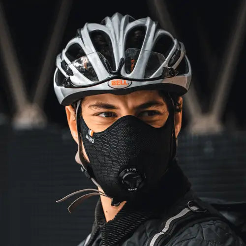 homme avec un masque antipollution et un casque de vélo
