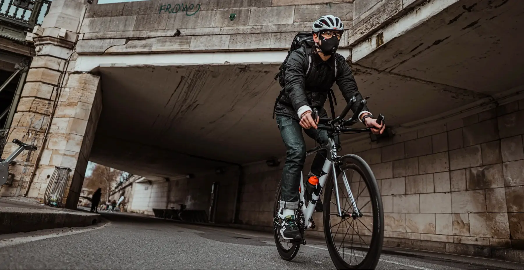 homme sur un vélo qui passe sous un pont