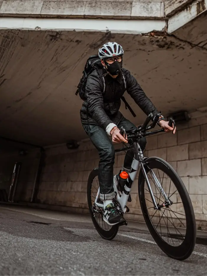 homme sur un vélo qui passe sous un pont