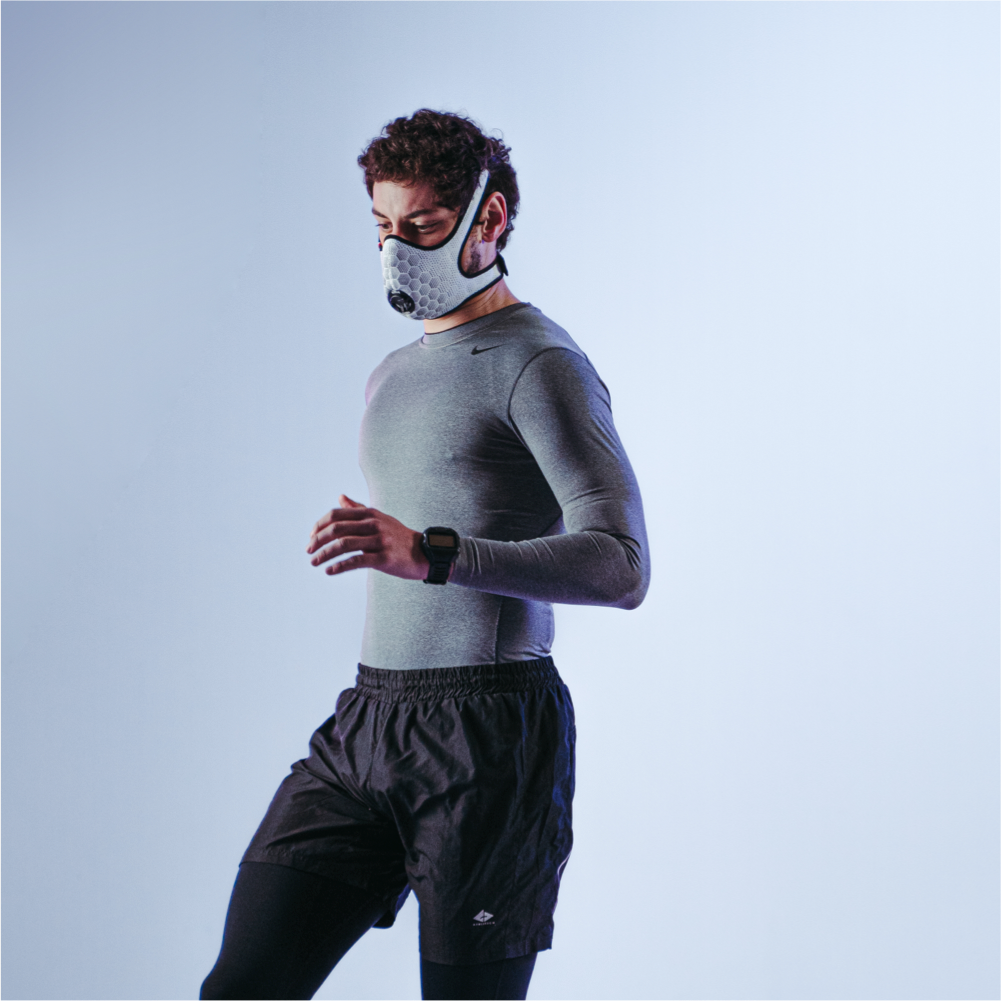Runner wearing a white R-PUR running mask looking to the side and down