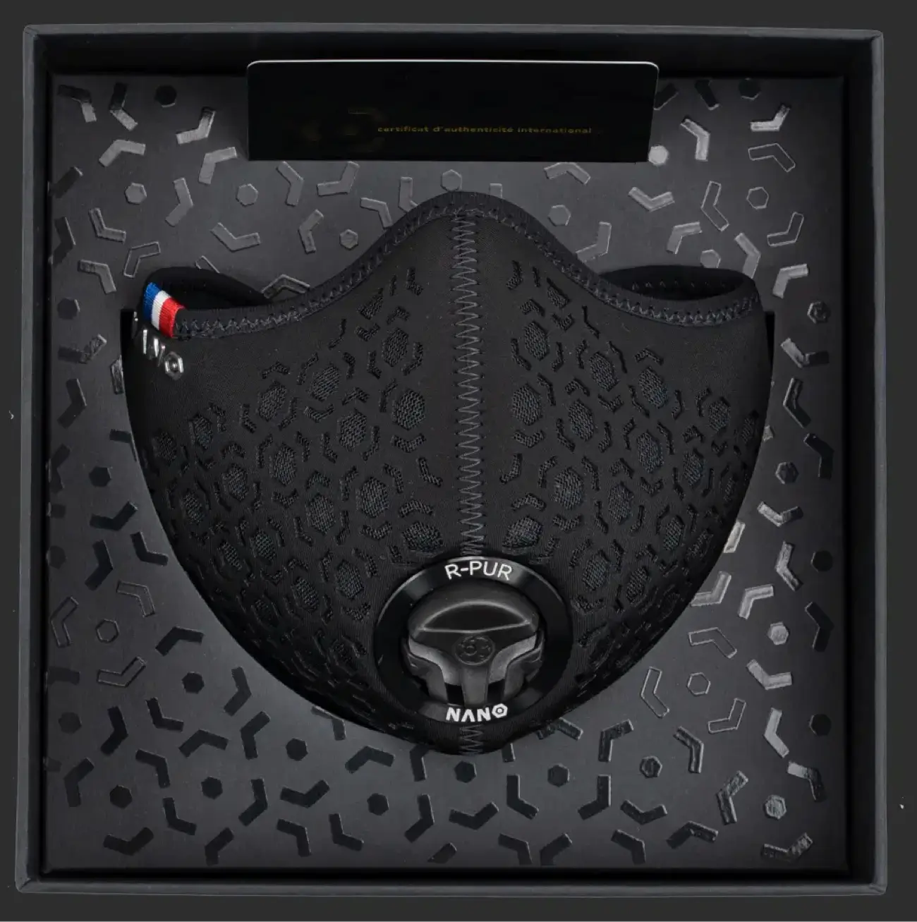 Black R-PUR mask presented inside a patterned retail box, valve and logo visible