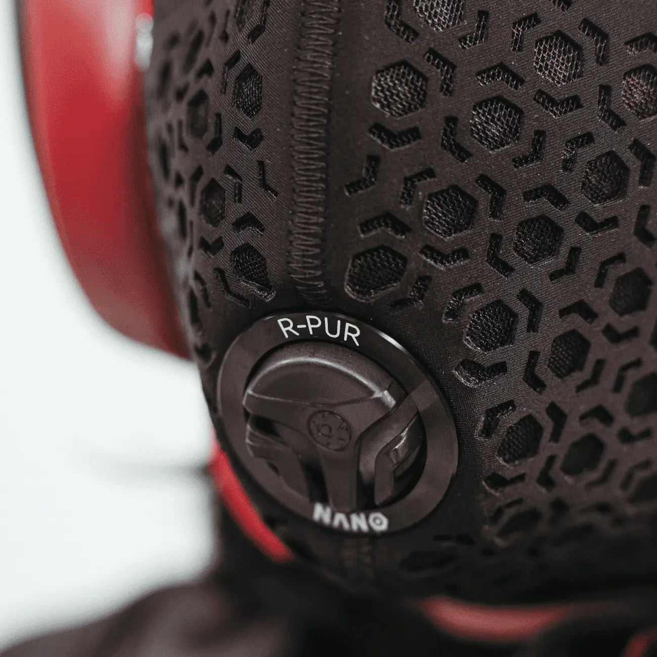 Detail of the R-PUR Nano one mask valve and hex-pattern fabric next to red helmet padding
